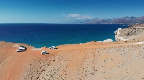 Cars on mountain by seascape