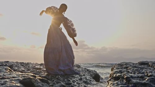 Woman In Lace Dress Dances At Rocky Shore