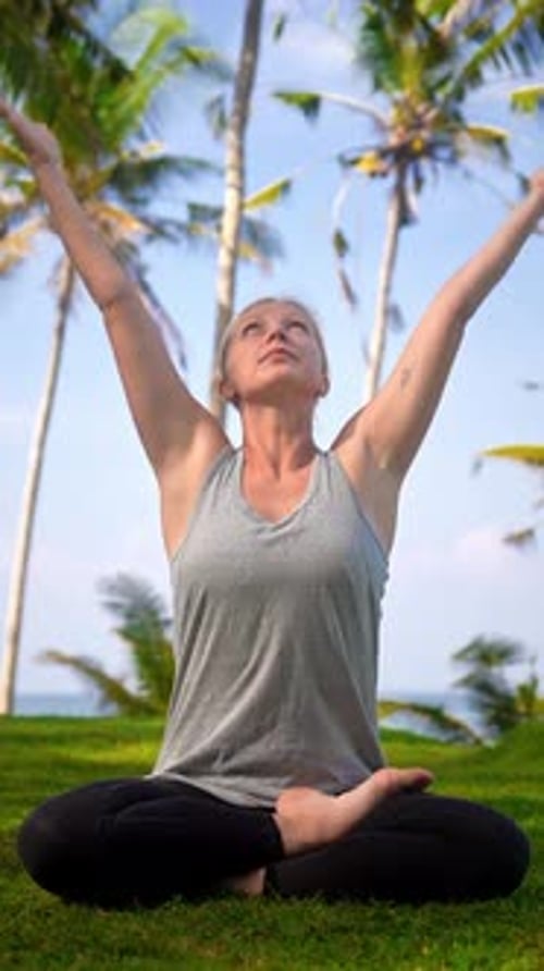 Woman Practices Yoga Outdoors in Tropical Setting