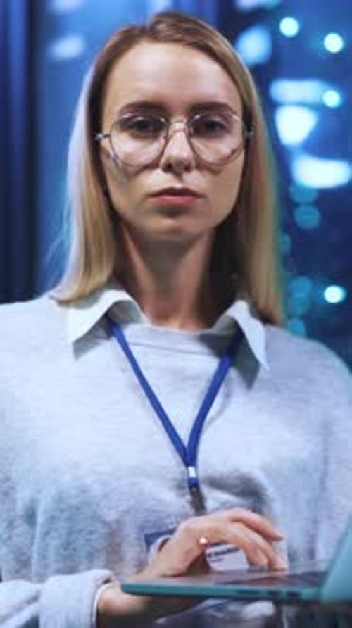 Woman Works on Laptop in Server Room