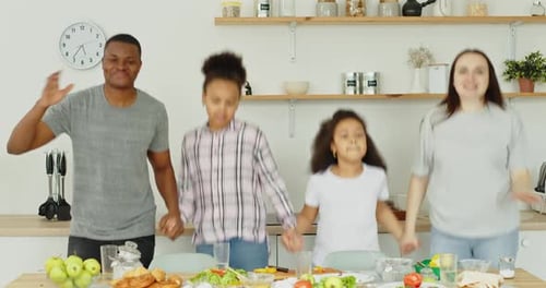 Happy Family Dancing Together in Kitchen