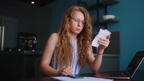 Stressed Woman with Receipts at Kitchen Table