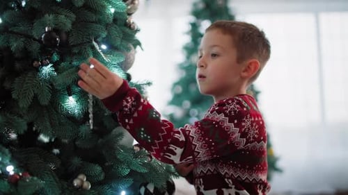 Boy Decorates Christmas Tree with Holiday Cheer