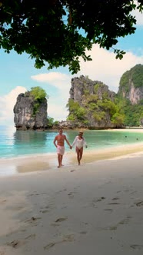 Couple Enjoying a Romantic Stroll Along the Serene Beach in Thailands Stunning Landscape