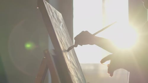 An Artist is Meticulously Painting on a Canvas in a Sunlit Studio Displaying Dedication Creativity
