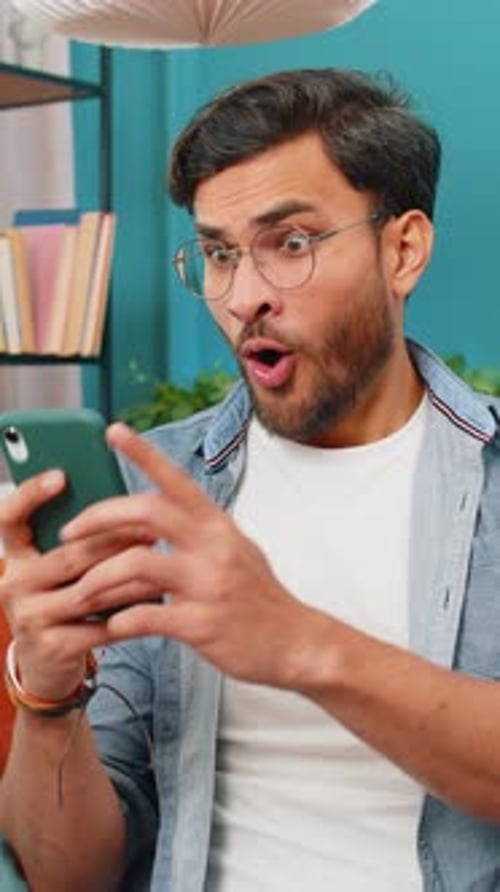 Young Man Reacts Positively to Mobile Phone News