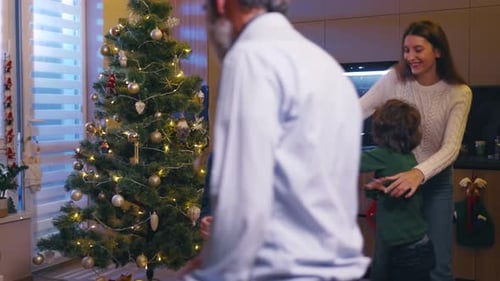 Family Celebrates Christmas with Dancing by the Christmas Tree
