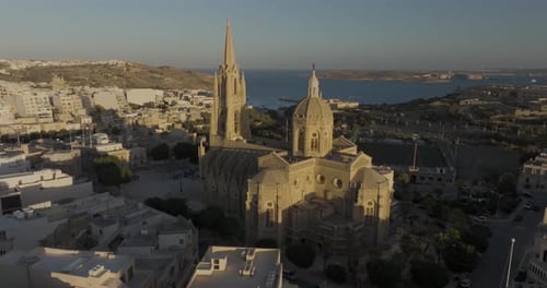 Aerial view of Nadur Parish Church and town by the coast, Gozo, Malta.