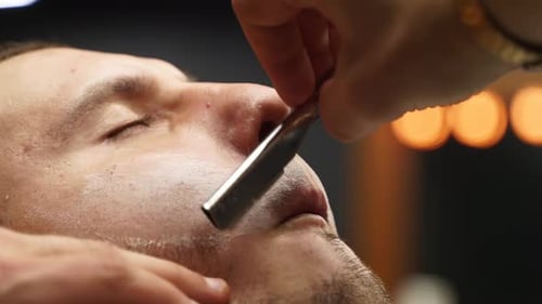 Man Getting Straight Razor Shave in Barber Shop