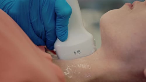 Thyroid Ultrasound Procedure on Patient at Hospital Woman Reclined on Examination Table for Neck