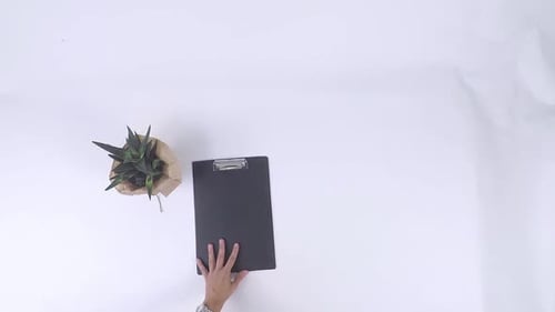 Top-down view of medical items placed on white background with a stethoscope, syringe, black dossier