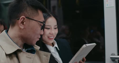 View of Cute Asian Couple Sitting Next to Each Other Inside Moving Metro or Train Girl Showing