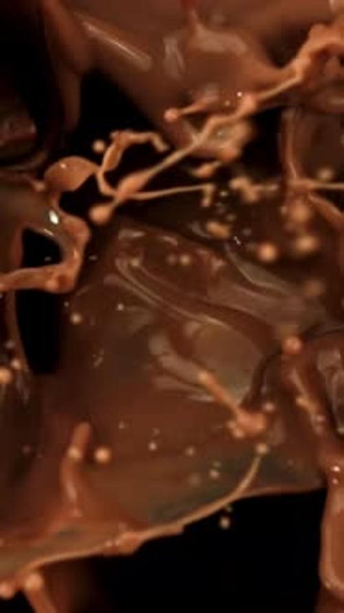 Super Slow Motion Dark Chocolate Chunks Fall Into Liquid Chocolate Filmed on a Highspeed Camera at