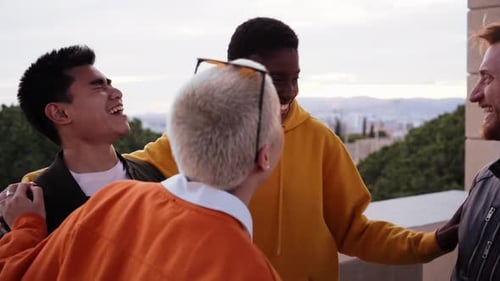 Four Friends Laughing Together on a Balcony