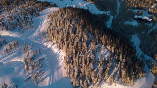 A drone shot of snowy Big Sky, Montana in winter, showcasing the ski resort and majestic mountain te