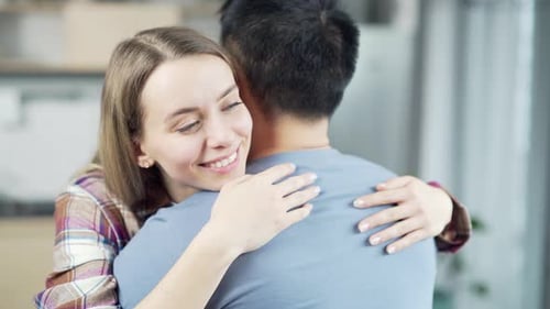 Smiling Woman Embraces Man Inside Home