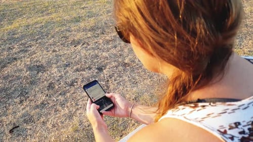 View of female person using a mobile phone