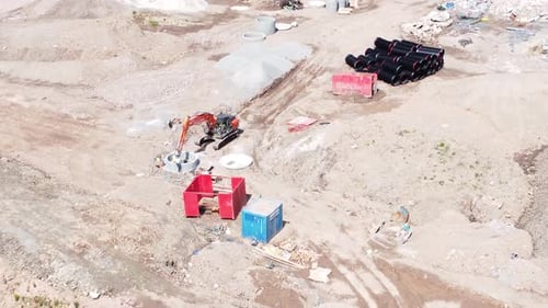 Vehículo excavador que prepara una tubería de concreto vista aérea sobre la construcción de un complejo de viviendas si