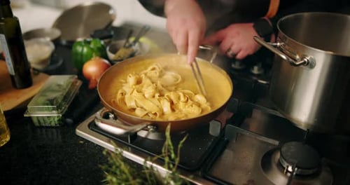 Hands cooking food in a pan at home