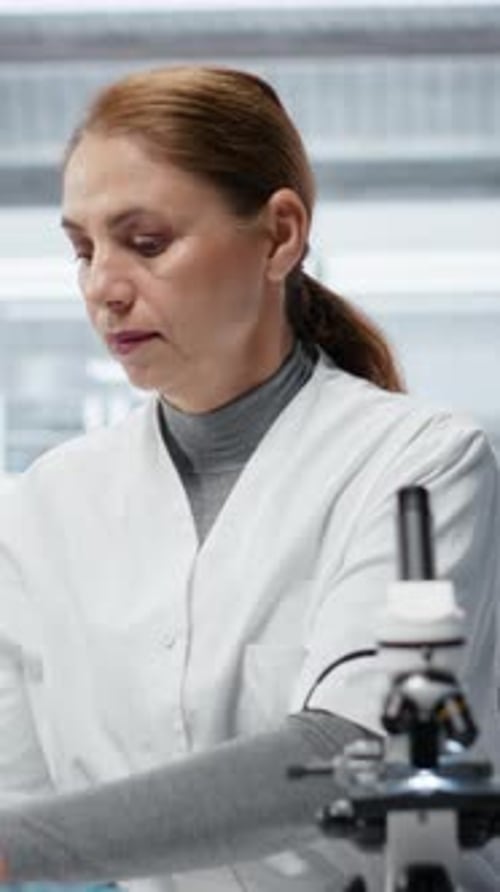 Woman Analyzing Blood Sample in Lab