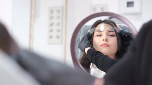 Woman Getting Eyebrows Measured at Beauty Salon