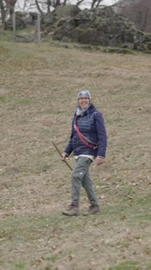 Senior Woman Hiking on Grassy Mountain Trail