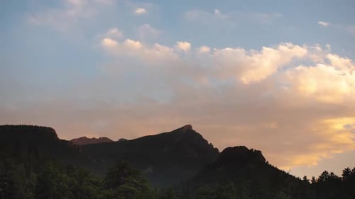 Felsiger Berggipfel mit wunderschönem Sonnenuntergang im Hintergrund mit farbenfroher Wolkenlandschaft