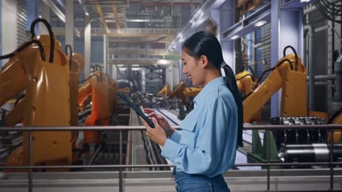 Young Adult Woman Using Tablet in Robot Factory