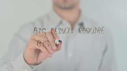 Man Writing Business Strategy on Clear Surface