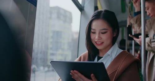 Young Adult Using Tablet on Public Transportation