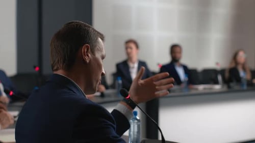 Business Meeting with Man Speaking at Podium