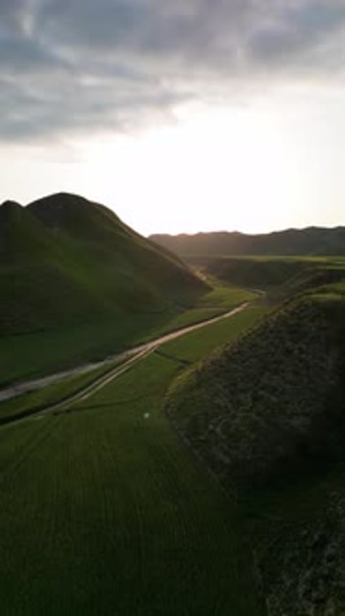 Sobrevoe o rio aéreo de um vale verde sobre campos, colinas, terras altas no Irã, natureza, pôr do sol, pastagem do Golestan