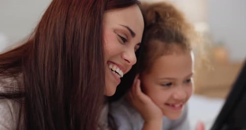 Mother and Child Laughing at Tablet Content