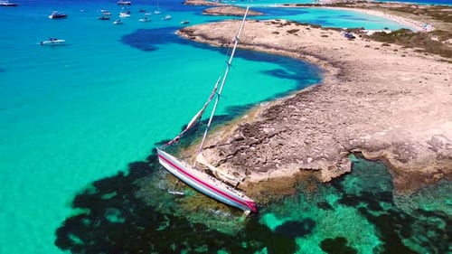 Sailboat stranded on cliff beach in formentera . Breathtaking aerial view flight drone