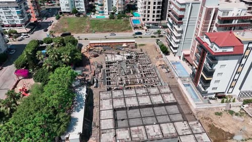 Trabajadores de vista aérea atando barras de refuerzo para una base de concreto en un sitio concurrido