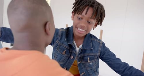 Happy african american father and son embracing at home, slow motion