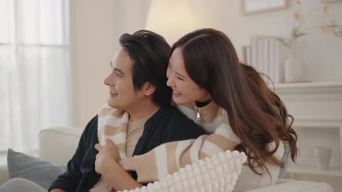 Affectionate Couple Embracing on Sofa in Bright Home
