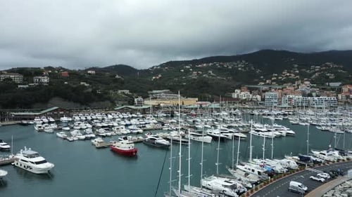 Seehafen mit Booten und Yachten, die am Pier festgemacht sind. Luftaufnahme an einem bewölkten Tag.