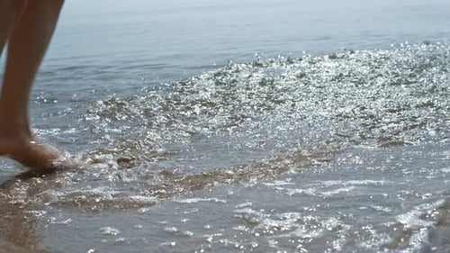 Young Girl Feet Jumping on Sea Waves Close Up. Unknown Carefree Barefoot