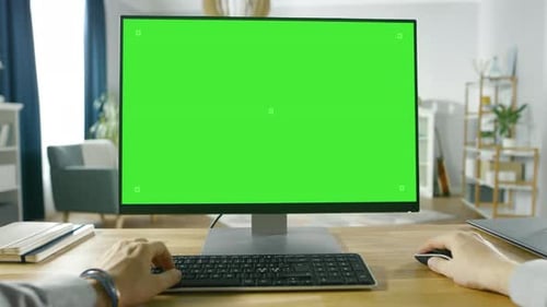 Ansicht eines professionellen Freelancers aus der ersten Person, der an einem PC mit grünem Mockup-Bildschirm arbeitet von
