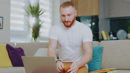 Man Working on Laptop Computer at Home