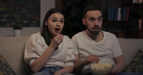 Beautiful Couple Watching Horror Movie Filled with Jump Scares Tenses Moments Woman Visibly Scared