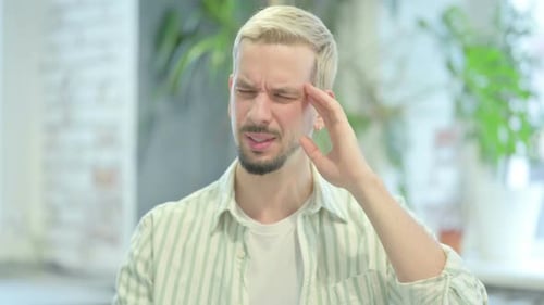 Young Man Experiencing Bad Headache, Touching Temples