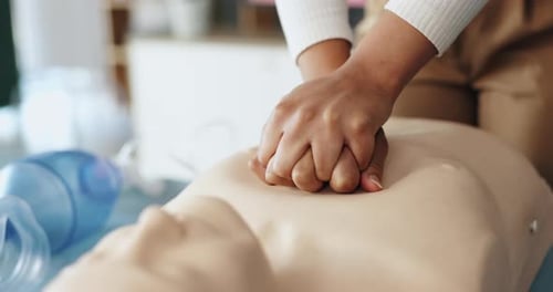 Hands Doing CPR on Training Dummy