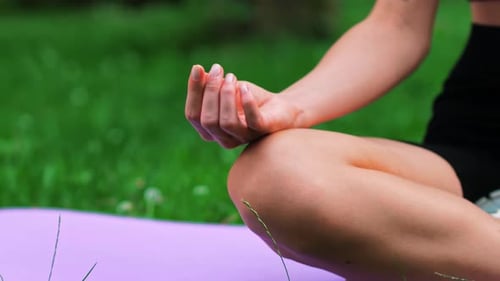 Woman Meditating Outdoors in a Green Park