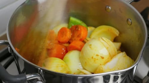 Cooking Video. Close up of food cooking simmering in a pan full of curry sauce, soup or stew placing
