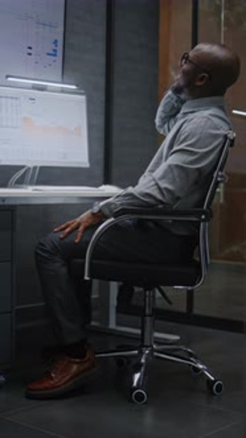Happy Stock Broker Monitoring Exchange Market Charts Talking on Phone