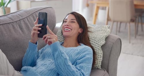 Happy Woman Using Smartphone on Couch at Home