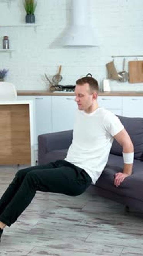 Man Doing Tricep Dips on Couch in Kitchen