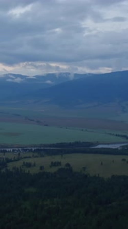 Panoramablick auf das Zamul'ta-Tal und das Altai-Gebirge unter Gewitterwolken